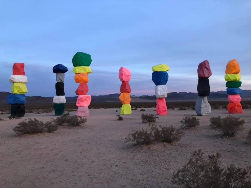 colorful seven magic mountains art installation outside at dusk
