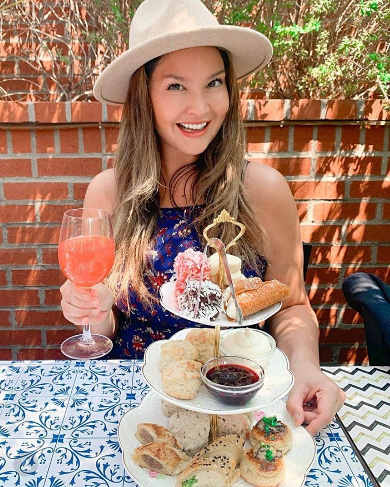woman eats brunch outside with food tower