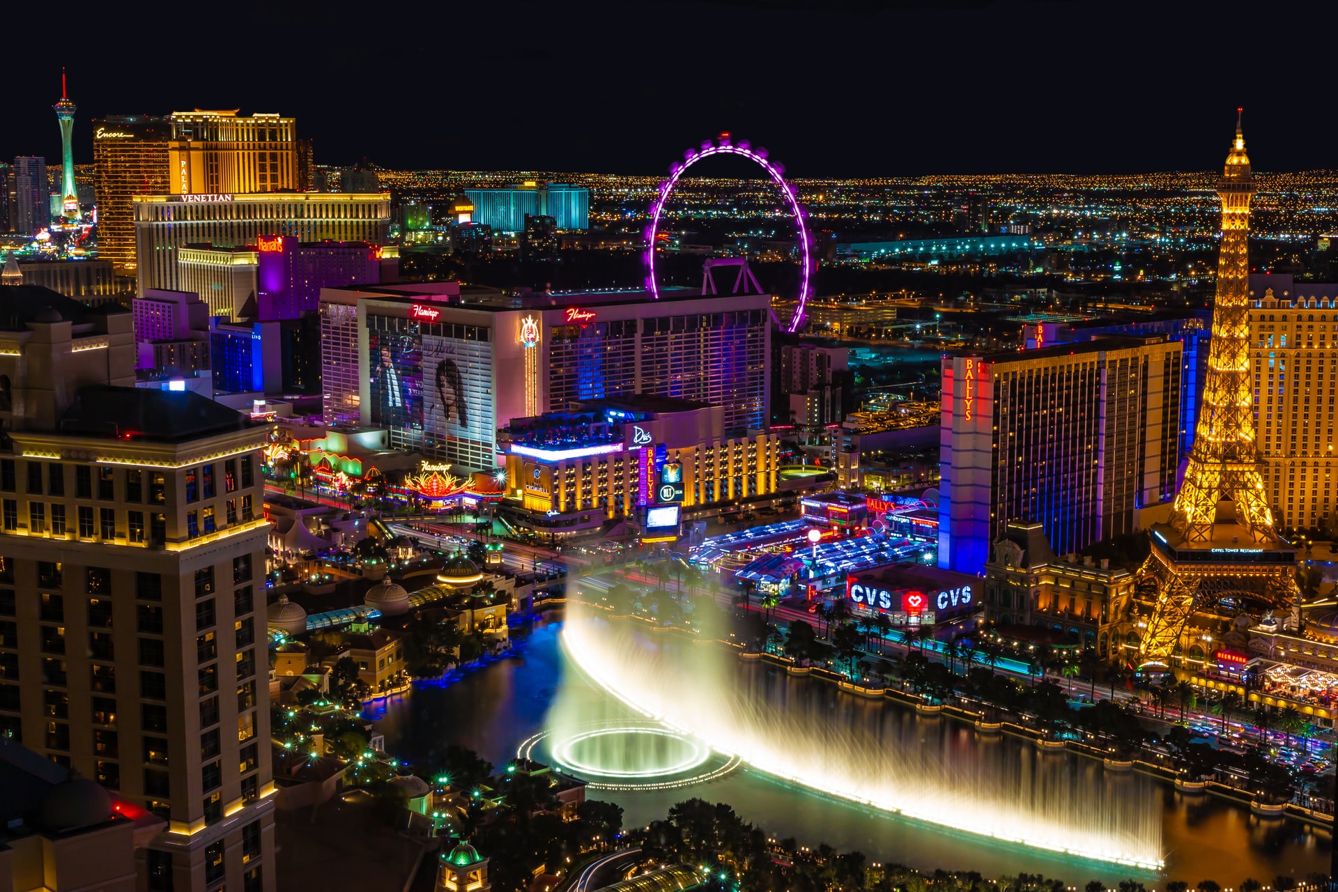 aerial of las vegas strip with lights and fountain at night