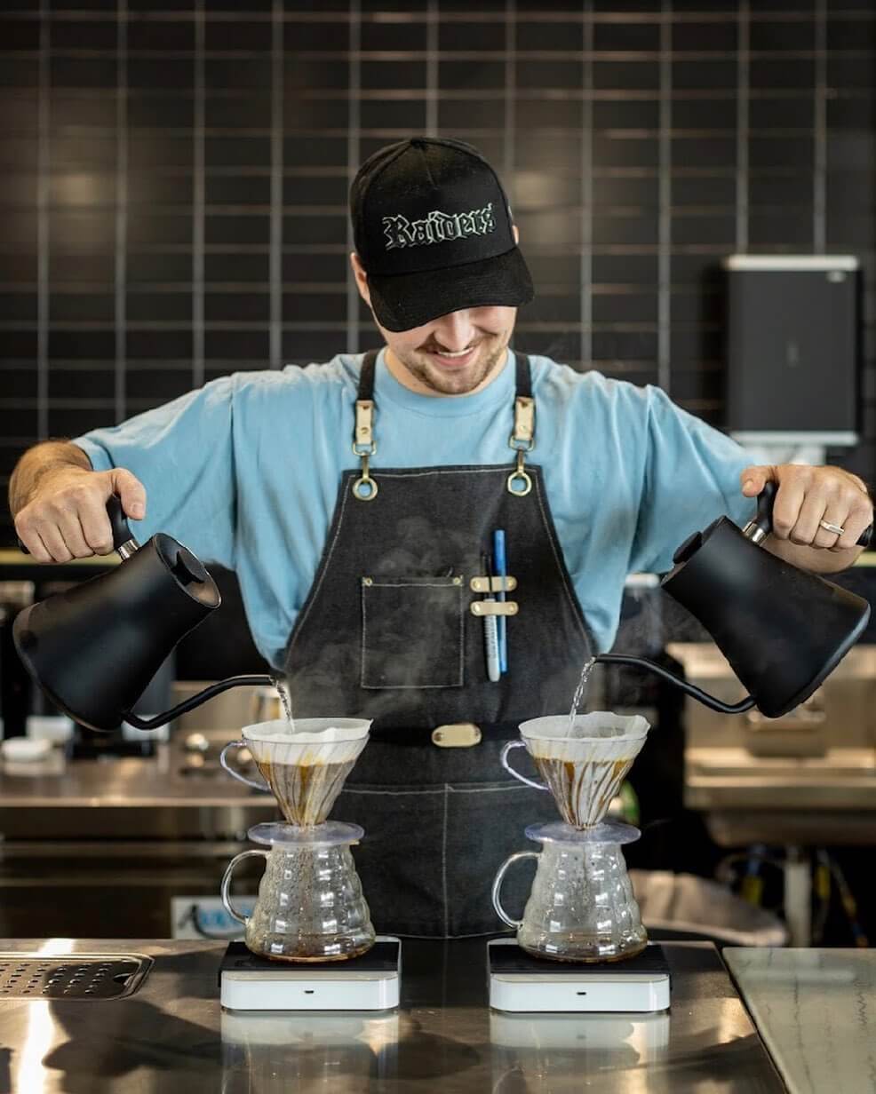 barista pours two coffees simultaneously