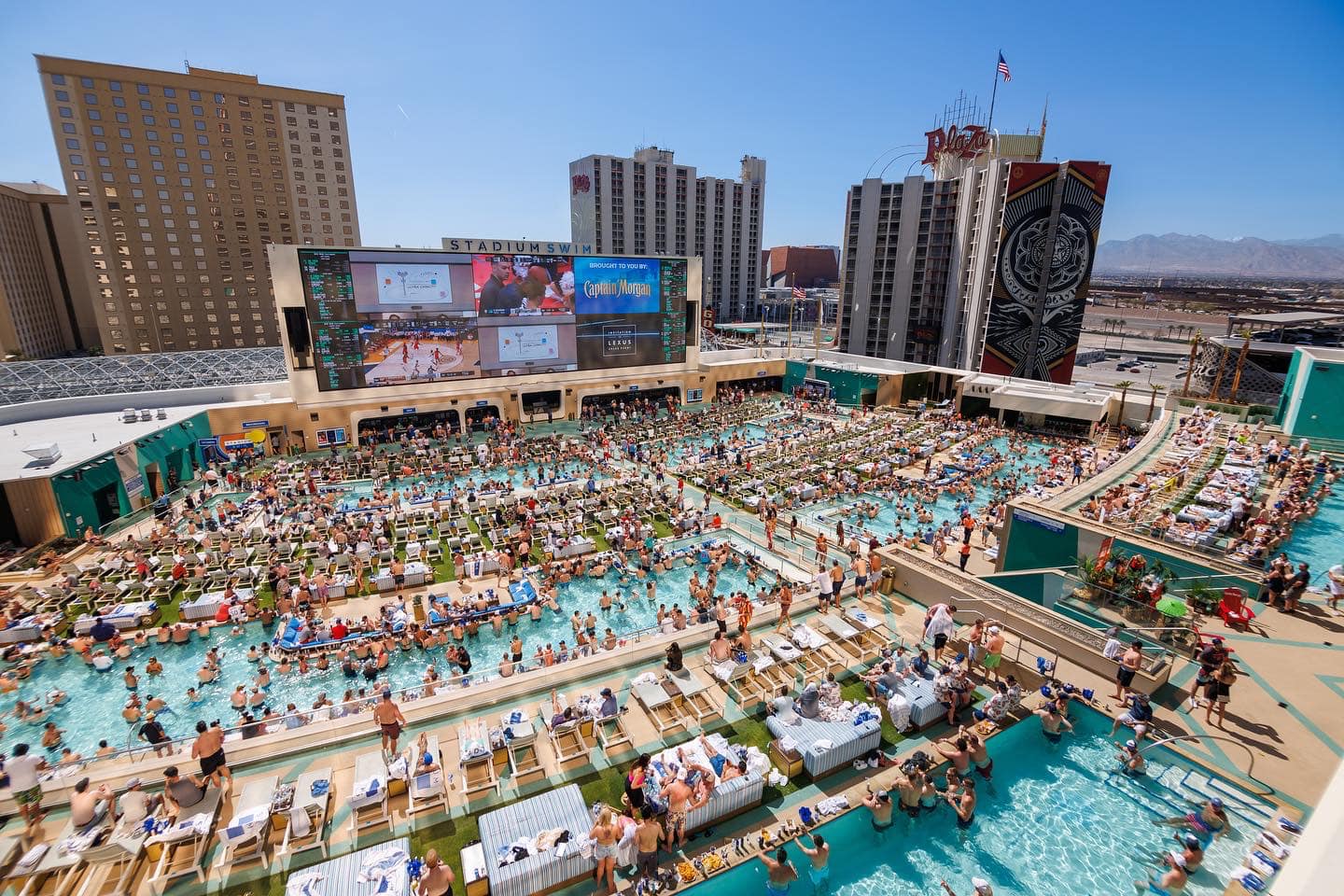crowded pool party surrounded by las vegas buildings