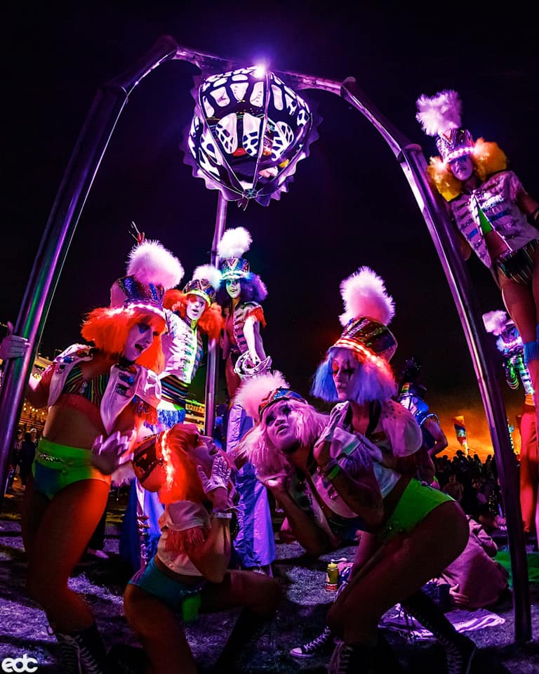 performers dance under neon lighting