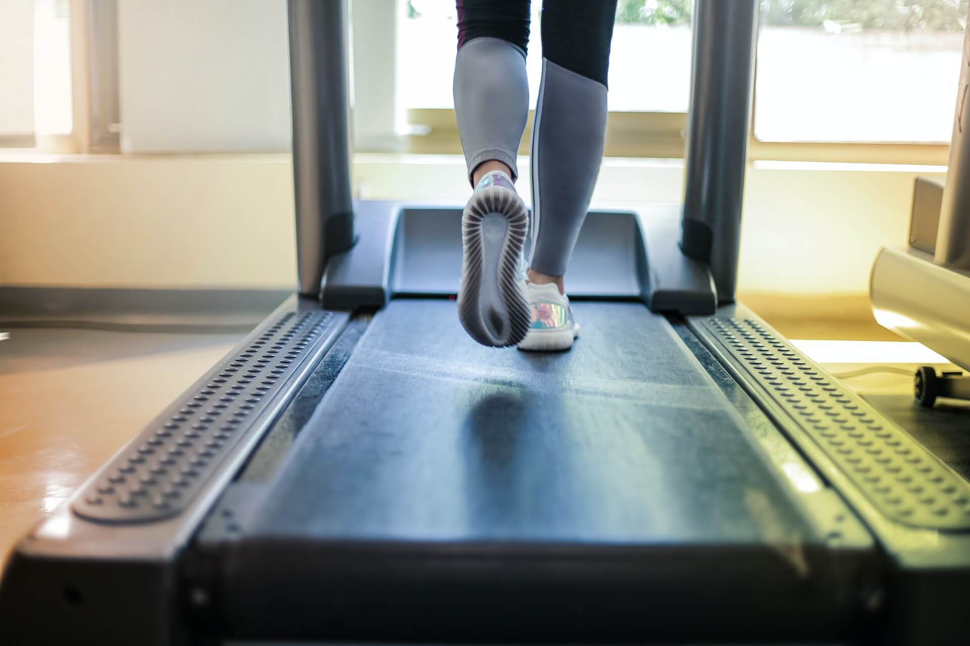 woman feet shown running on treadmill