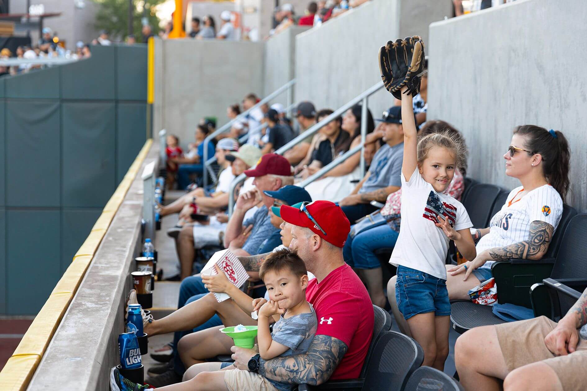 kids watch baseball game on parents lap