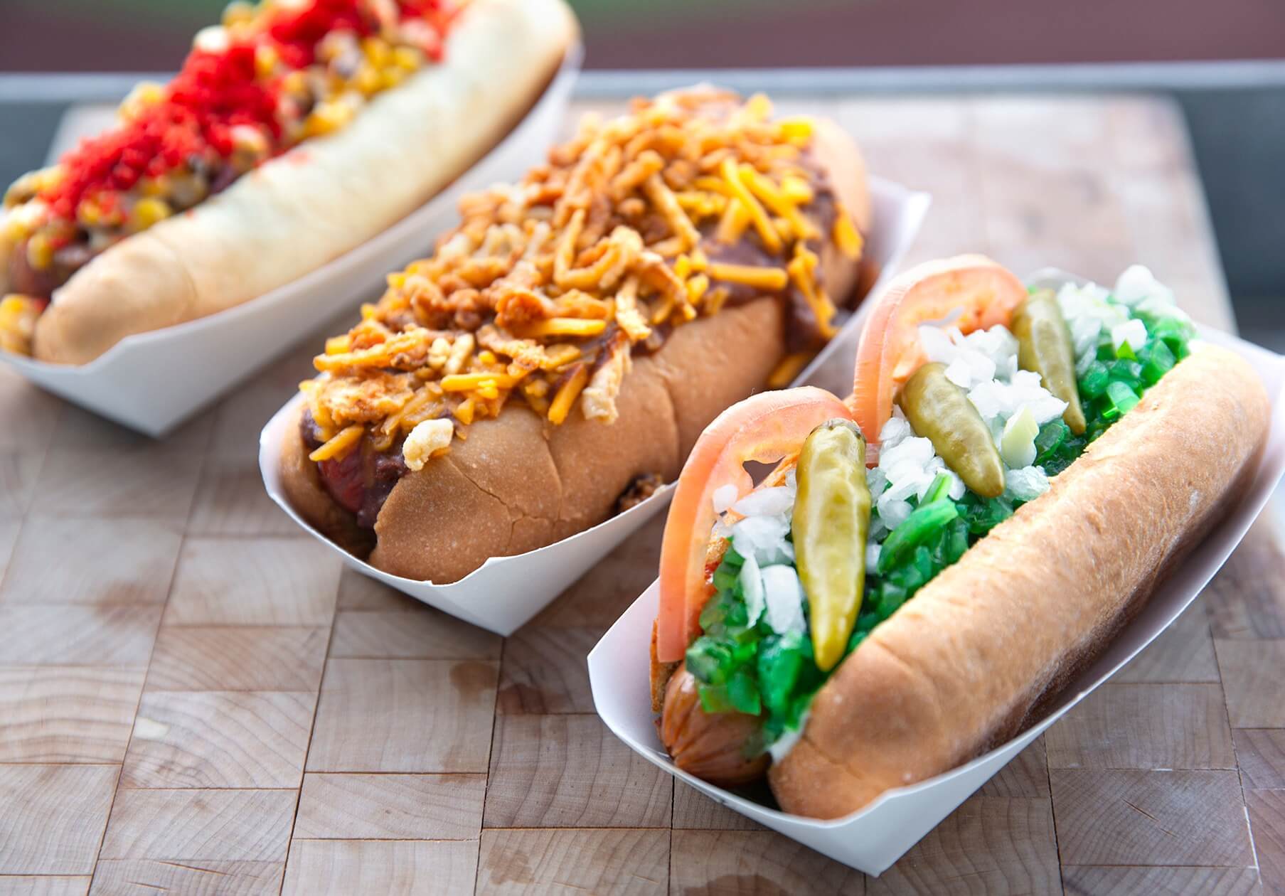 three gourmet hotdogs with inventive toppings 
